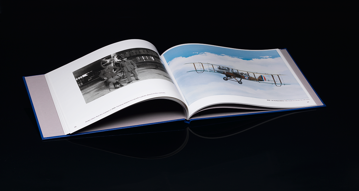 Book with airplane photos lying open on dark background