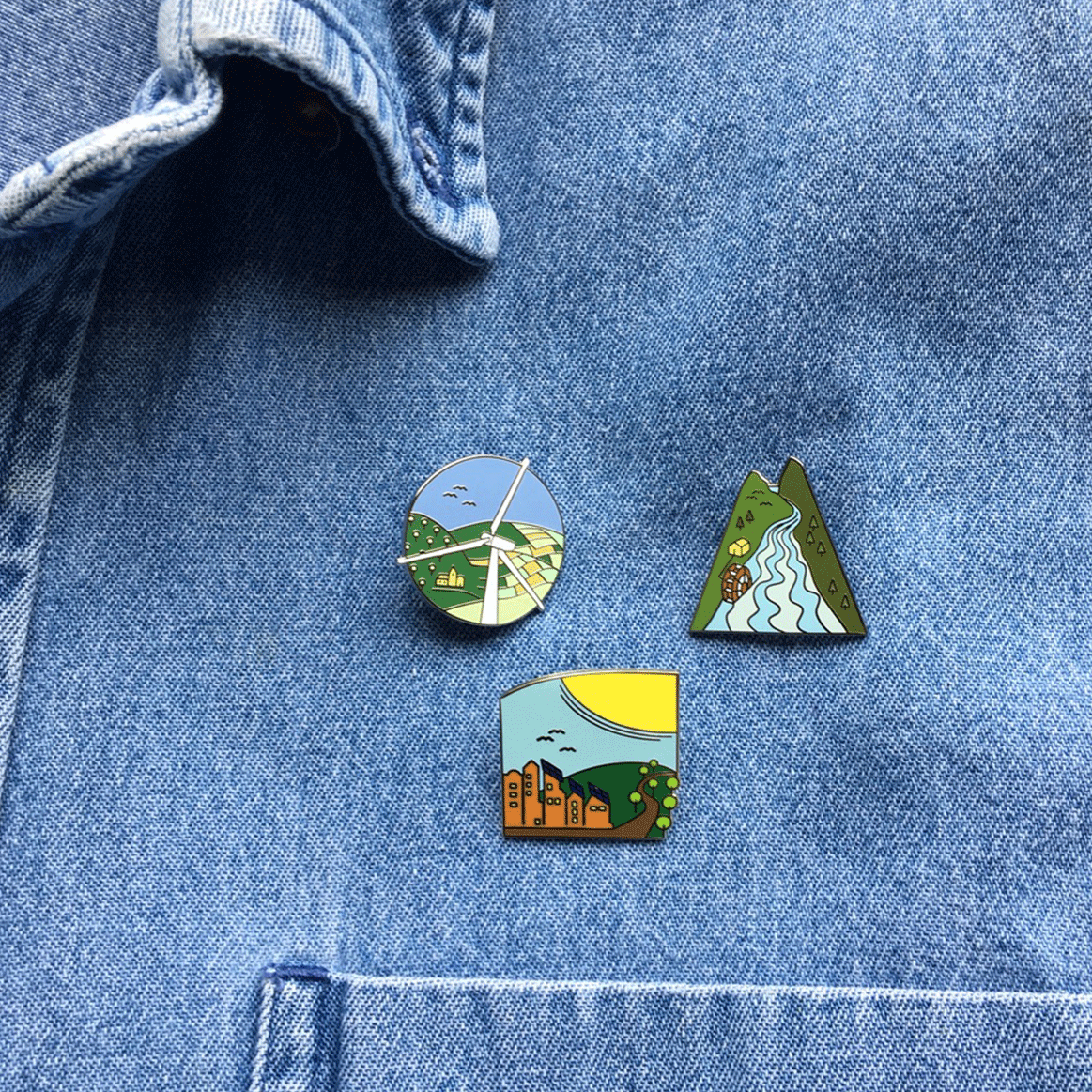 Three Sustainable Energy pins on denim shirt