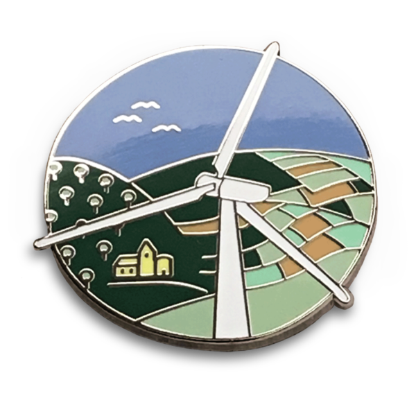 Pin face of white wind turbine looking over farm fields, orchard, village, birds in sky