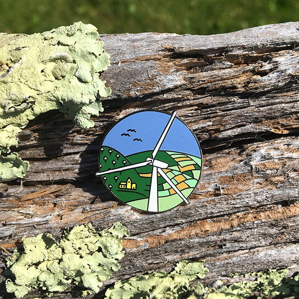 Wind power pin on old wood fence rail with lichen.