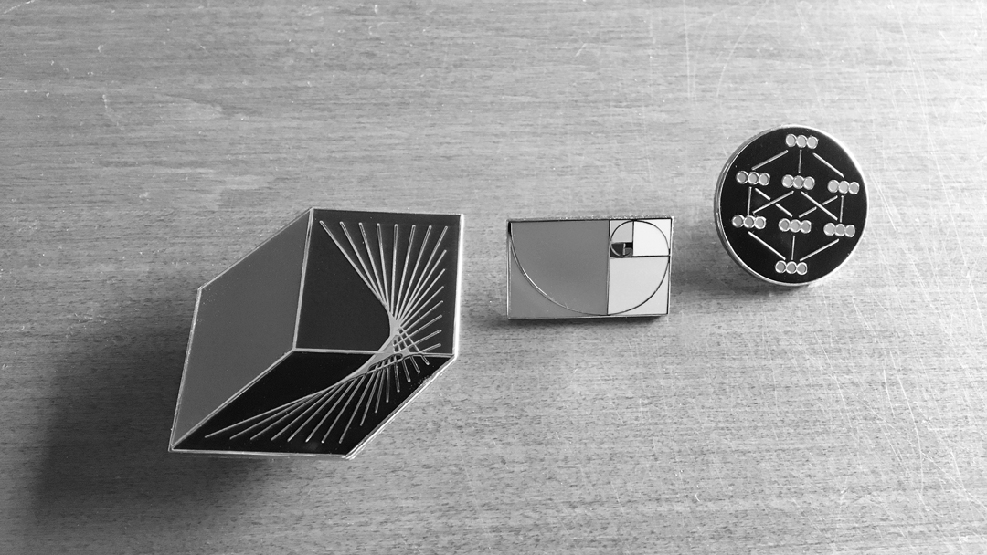 Black-and-white-of-three-math-pins-on-table