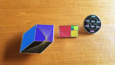 Three-math-pins-on-wood-desk