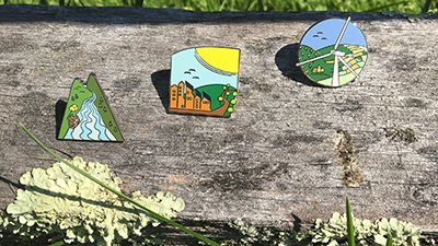 sustainable-energy-pins-on-fence-rail-with-lichen